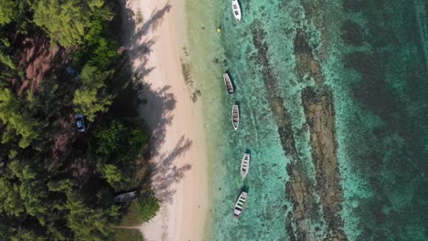 Aerial-4K-Top-Down-Shot-of-Clear-blue-water-along-beach-with-white-boats-in-focus-and-perfect-symmetry-,-Balaclava,-Mauritius