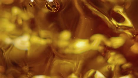 A-glass-is-slowly-filling-with-ambar-liquid-in-slowmotion-and-macro
