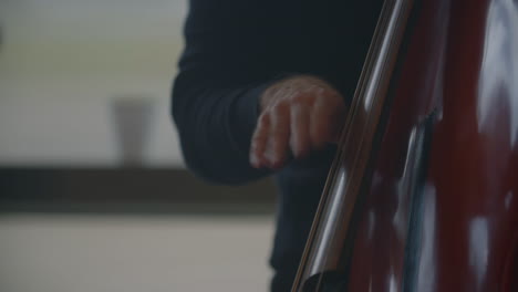 Ein-Mann-Zieht-Die-Saiten-An-Einem-Musikinstrument