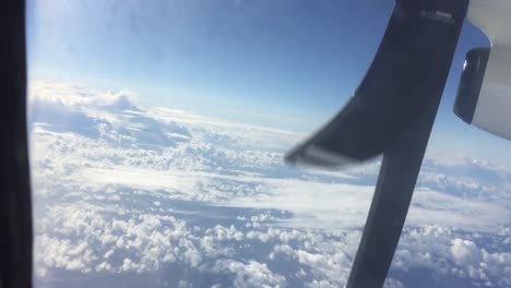View-of-clouds-looking-through-window-in-propeller-aircraft