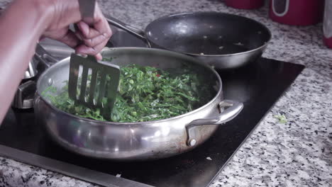 Woman-cooking-collard-greens-in-skillet