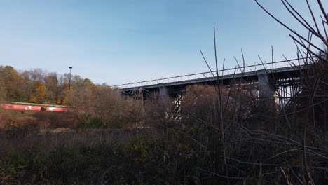 Wide-motion-time-lapse-of-traffic-on-Toronto's-Danforth-Viaduct-and-Don-Valley-Parkway,-shot-from-below