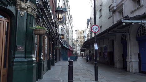 Two-women-in-protective-face-masks-walk-through-an-empty-alleyway-and-passed-closed-businesses-near-Covent-Garden-during-the-second-national-Coronavirus-lockdown