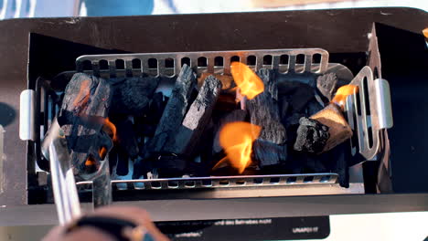 Placing-charcoal-in-a-small-grill-to-start-the-fire