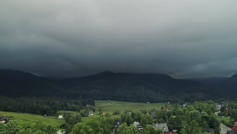 Friedliches-Dorf-Mit-Fernblick-Auf-Grasende-Schafe-Und-Bewaldete-Berge-Im-Hintergrund