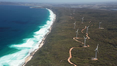 Aerial-view-overlooking-a-wind-farm,-at-the-ocean,-in-Albany,-Australia---tracking,-drone-shot