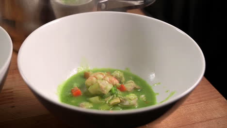 Ladling-A-Freshly-Cooked-Peruvian-Cilantro-Seafood-Soup-Into-A-White-Bowl