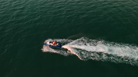 Drone-close-flyover-a-jetski-with-two-people-onboard,-Abu-Dhabi