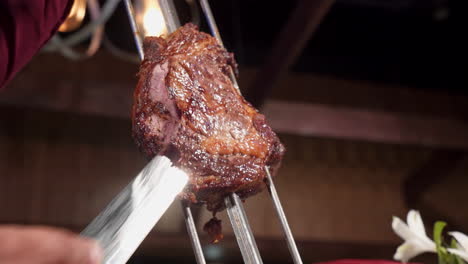 Gaucho-Schneidet-Saftiges-Rindfleisch-Vom-Spieß-Im-Brasilianischen-Steakhouse,-Zeitlupe-4k