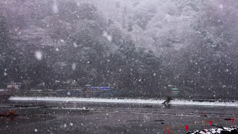 Snowflakes-over-Katsura-River-at-Arashiyama,-Kyoto