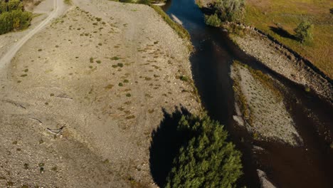 Aerial-tilt-up-shot-of-a-river-in-the-countryside-of-New-Zealand
