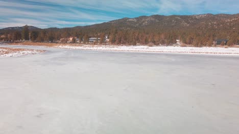 Hochkippen-Eines-Zugefrorenen-Sees,-Der-Mit-Schnee-Bedeckt-Ist