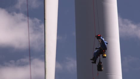 Worker-tied-with-the-safety-harness-and-hanging-from-high-rise-wind-turbine