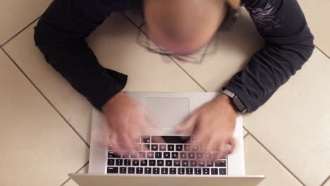 Time-lapse:-Close-Up-shot-of-caucasian-man-typing-on-laptop-keyboard,-on-the-floor