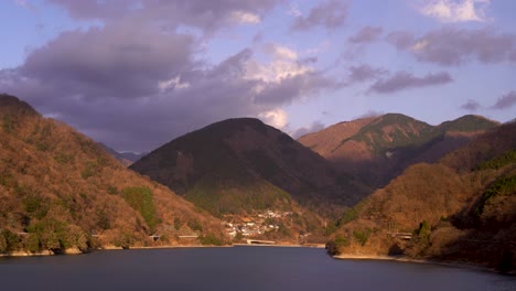 Beautiful-view-out-on-lake-and-small-village-in-mountains-at-sunset