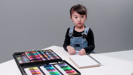 Child-choosing-black-pen-in-the-full-case-for-drawing