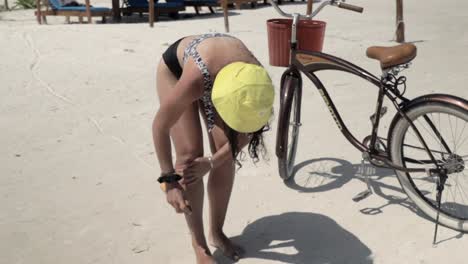 Caucasian-Female-Applying-Sunscreen-on-her-Skin,-with-a-Bicycle-in-the-Background