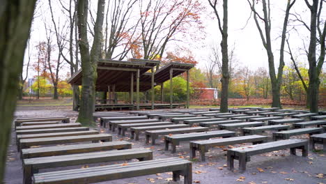 Empty-Wooden-Benches-And-Platform-At-The-Park-During-Autumn