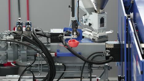 Geformtes-Kunststoffprodukt,-Das-Von-Einem-Roboterarm-Einer-Spritzgussmaschine-Transportiert-Wird
