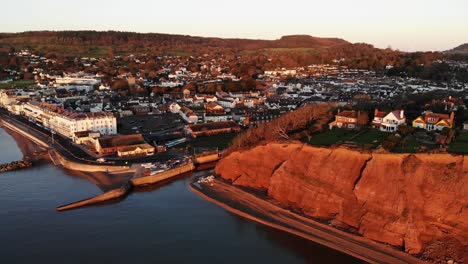 Aerial-View-Of-Sidmouth-Town-Beside-Coastline-Bathed-In-Golden-Sunrise-Light
