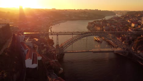 Aerial-view-above-Porto-Portugal-historical-European-cityscape-following-rive-Douro-downtown-waterfront,-glowing-sunset
