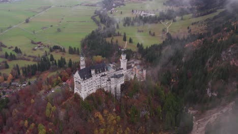 Prestige-Neuschwanstein-Castle-overlooking-countryside-kingdom-with-green-pastures,-aerial