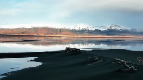 Remains-Of-Shipwreck-Covered-With-Black-Sand-With-Scenic-Mountains-Views-In-Iceland