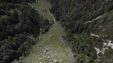 Descriptive-back-up-back-shot-drone-video-over-Vrsc-pass-in-Slovenia-with-mountains-on-the-horizon