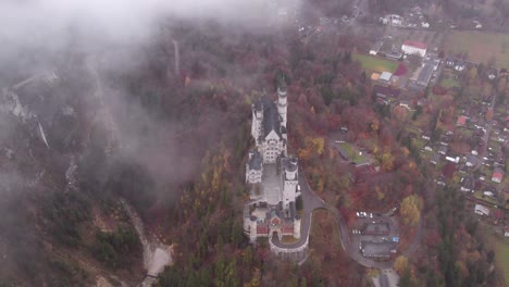 Flying-through-clouds-with-view-of-idyllic-medieval-Neuschwanstein-castle-on-hill