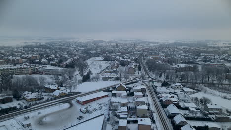 Aerial-view-of-lubawa-after-big-snow-storm-in-winter,-drove-fly-above-the-poland-city-revealing-white-cityscape