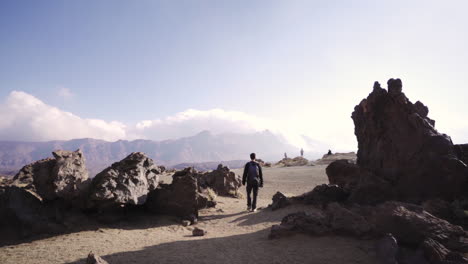 Pan-left-of-Caucasian-man-exploring-desert-landscape-in-Teide-National-park