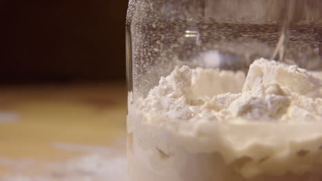 SLOW-MOTION-CLOSE-UP,-sourdough-starter-is-mixed-with-spoon