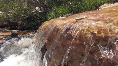 Agua-Cristalina-Que-Fluye-Sobre-Una-Roca-En-Un-Arroyo-De-Montaña