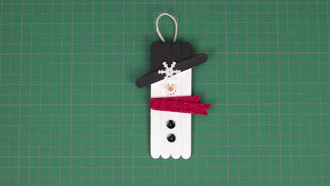 Snowman-made-with-popsicle-sticks-on-a-cutting-mat