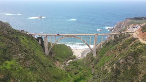 Autos-Conduciendo-En-El-Puente-Bixby-Creek-Con-Un-Mar-Azul-Tranquilo-En-La-Costa-De-Big-Sur,-Monterey,-California