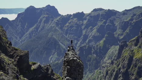 Heranzoomen-Auf-Einen-Mann,-Der-Auf-Einem-Kleinen-Felsvorsprung-Steht-Und-Vulkanberge-überblickt