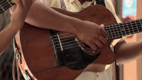 Hispanic-Male-Playing-Old-Guitar,-Showing-Arms-Only