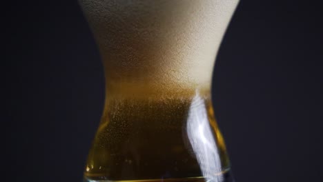 Burbujas-De-Cerveza-En-Un-Vaso-Lleno-De-Cerveza-Formando-Carbonatación-A-Través-De-Vidrio-De-Tulipán-En-Un-Estudio-Oscuro-Video-De-Producto-De-Carbonatación-En-Cámara-Lenta