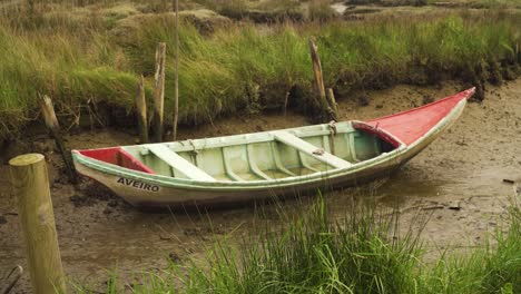 4K-old-wood-fishing-boat-stranged-on-the-muddy-banks-of-a-low-tide-river