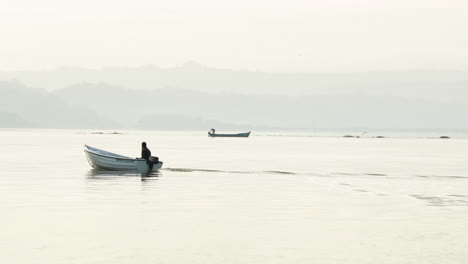 Fisherman-On-Motorboat-Sailing-On-Calm-Water-Of-Obidos-Lagoon-Near-Foz-do-Arelho-Beach-In-Portugal