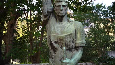 Socialist-realism-statue-of-worker-holding-rifle-and-pickax-on-hands