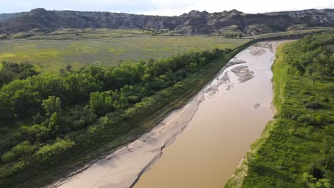 Flying-over-Little-Missouri-River-at-an-angle-just-outside-of-Theodore-Roosevelt-National-Park-in-North-Dakota-on-a-summer-day