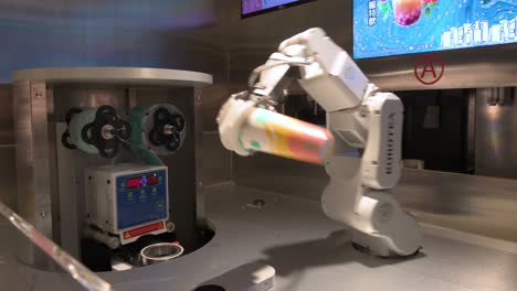 An-automated-robot-arm-prepares-a-beverage-for-a-customer-by-combines-elements-of-engineering,-mathematics,-and-AI-technology-at-a-shopping-mall-tea-store-in-Hong-Kong