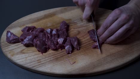 Man-Slicing-Fresh-Beef-Meat-On-Wooden-Board---Close-up