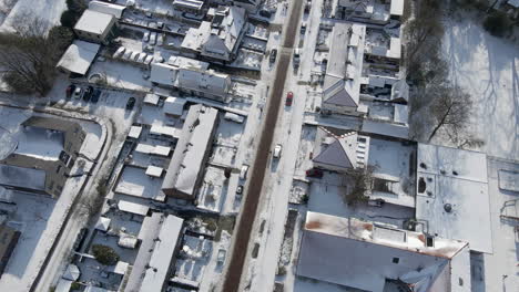 Aerial-of-clean-road-running-through-snow-covered-suburban-neighbourhood