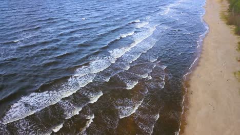 Luftaufnahme-Von-Ruhigen-Meereswellen,-Die-An-Einem-Sonnigen-Tag-Die-Sandküste-Erreichen