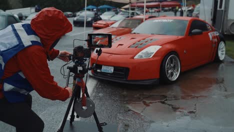 Camera-man-in-high-visibility-vest-films-sports-car-at-a-car-show