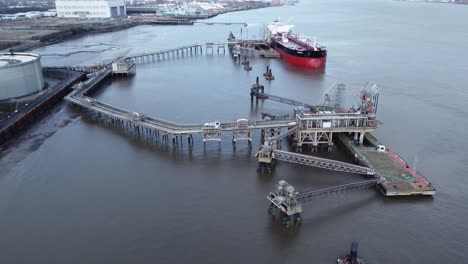BELMAR-crude-oil-tanker-boat-loading-fuel-cargo-at-UK-refinery-terminal-aerial-view-orbit-left-above-pier