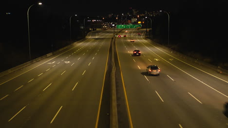 Tráfico-Intenso-En-La-Autopista-Canadiense-Durante-La-Noche-Con-El-Horizonte-De-Vancouver-En-Segundo-Plano.