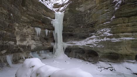 Frozen-waterfall-on-majestic-cliff-during-winter-season-snowfall